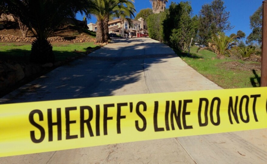 Crime tape stretches across the driveway of a 3,500-square-foot home in Encinitas that sheriff's officials described as suspected "drug house," Dec. 23, 2014.