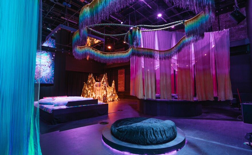 <em>Back Power Naps,</em> 2019, is an elaborate arrangement of plush beds and bean bags in a spacious, black box theater by interdisciplinary artist Navild Acosta. "The deliberate fragmentation of restorative sleep patterns was used to subjugate and extract labor from enslaved people ..." Acosta writes. And today, "a state of constant fatigue is used to break our will."