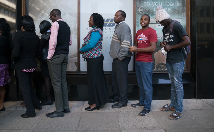 Zimbabweans stand in line in front of NMB bank in Harare. Zimbabwe has been facing a major cash shortage for the past two years, a symptom of the country's larger and longer economic crisis.