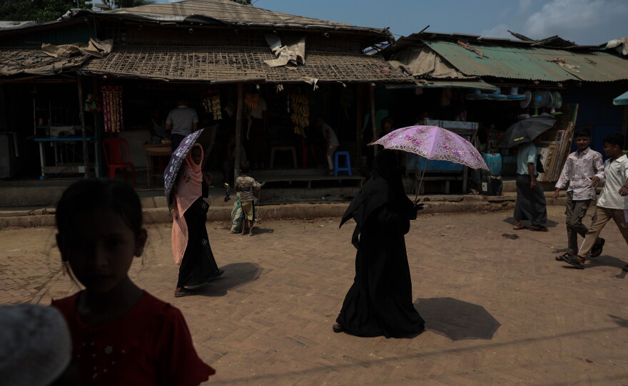 People walk past vendor stalls in a Rohingya refugee camp in Cox's Bazar, Bangladesh, April 21, 2026.