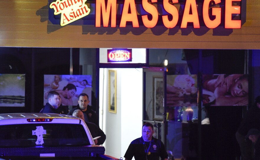 Authorities investigate a fatal shooting at a massage parlor, late Tuesday, March 16, 2021, in Woodstock, Ga. 