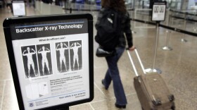 A woman passes by a security sign at Seattle-Tacoma International Airport on Friday.