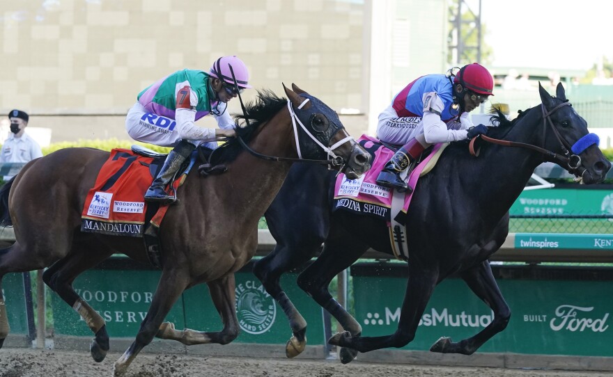 John Velazquez, right, rides Medina Spirit ahead of Florent Geroux aboard Mandaloun to win the 147th running of the Kentucky Derby at Churchill Downs on Saturday in Louisville, Ky.