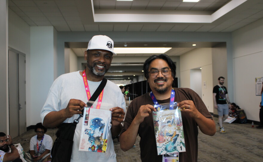 Comics creators Keithan Jones (left) and Bobby Rubio hold up a copy of their comics in the San Diego Convention Center, Thursday, July 23, 2026.