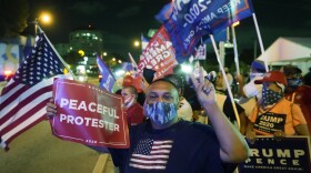 Supporters of President Donald Trump chant and wave flags outside the Versailles Cuban restaurant during an Election Night celebration, Tuesday, Nov. 3, 2020, in the Little Havana neighborhood of Miami. 