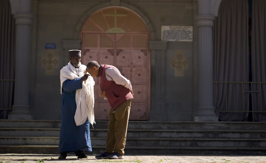 Monk performing blessing for Dr. Wassie