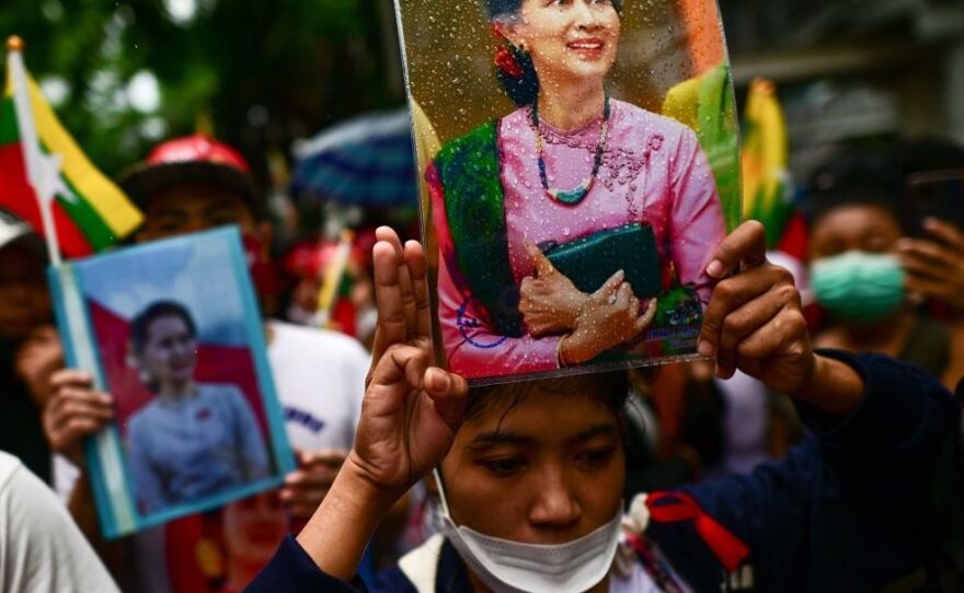 Protesters show the three finger salute and hold photos of detained Myanmar civilian leader Aung San Suu Kyi in July outside the Myanmar Embassy in Bangkok during a demonstration against the Myanmar military junta's execution of four prisoners.