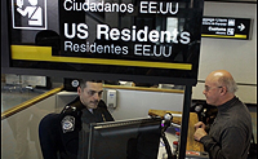 Anthony Ramos, a Customs and Border Protection officer, checks Martin Keenan in at the passport control area at Miami International Airport.