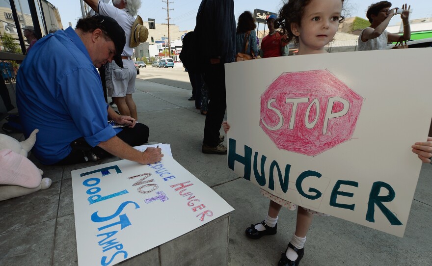 Gracie Shannon-Sanborn, 5, holds a sign as she joins her father Allen Sanborn (L) and members of Progressive Democrats of America at a rally in front of Rep. Henry Waxman's office on June 17, 2013 in Los Angeles, Calif. The protestors asked the congressman to vote against a House farm bill, which was defeated Thursday.