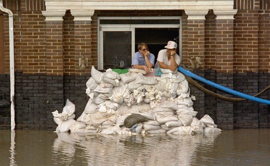 Mike Stone, left, and Andy Sherman in the pumping station for Hannibal, Mo., during a flood in 1993. The city has since constructed a flood wall, and flood managers have built up levees to protect against flooding. But scientists warn those structures are making flooding worse.