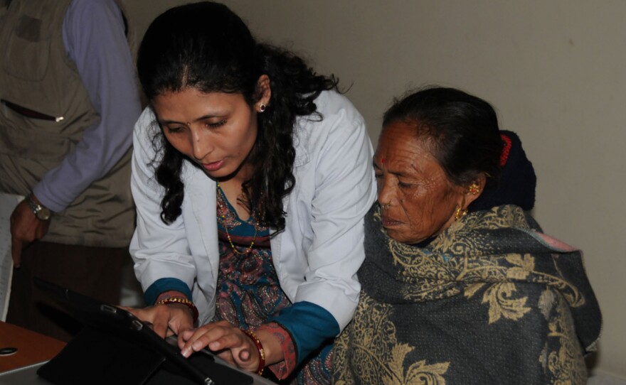 A researcher shows a woman in Nepal how to use a visual field test on an iPad. It's used to diagnose glaucoma.