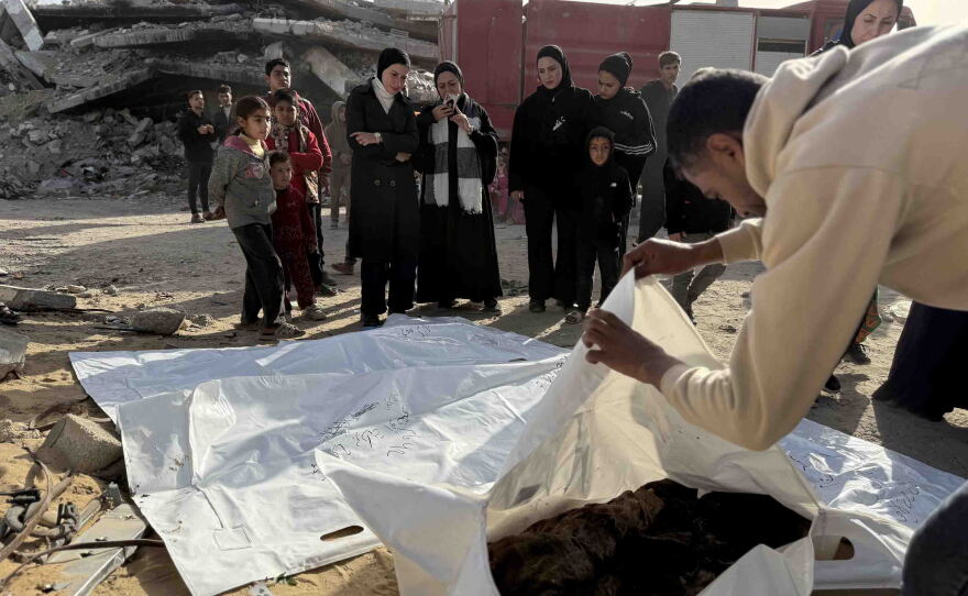 Mohammed Abu Naser, 35, a survivor of the strike, bids farewell to his deceased uncle Shawqi Abu Naser, whose body and dozens of others were recovered from beneath the rubble of the family's home destroyed in an Israeli strike, as other family members gather.