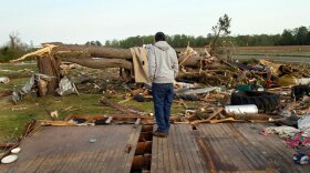 Clifton Perry stands on what's left of this home Monday in Colerain, N.C., where a tornado hit Saturday.