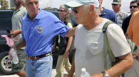 Florida Gov. Charlie Crist (left) and entertainer Jimmy Buffett walk along Pensacola Beach, where Buffett plans to open a new hotel.