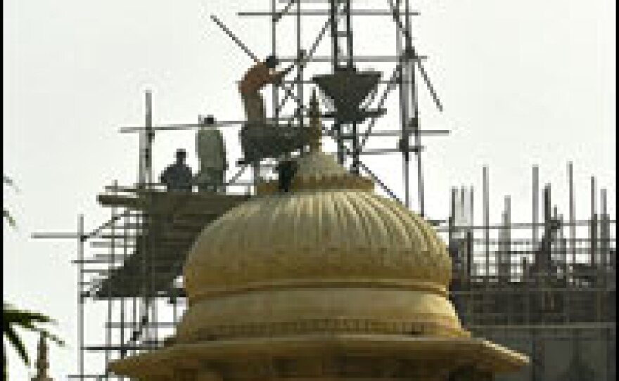 Pakistani laborers work on the construction of a multistory building in Karachi, Pakistan, which is attracting foreign investment in real estate developments.