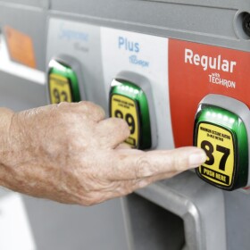 A man selects a grade of gasoline as he fills up his car at a gas station, June 4, 2014.