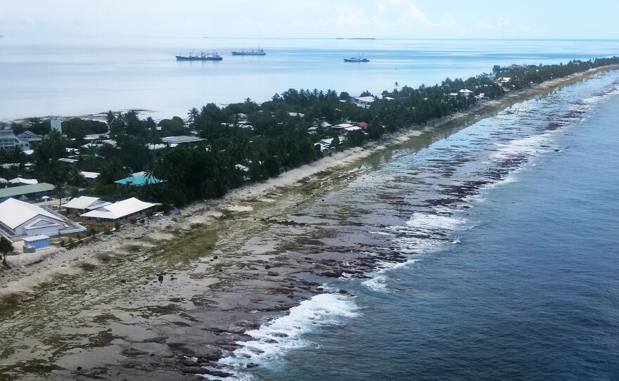 The ocean (right) and the lagoon (left) are separated by a thin strip of land in Funafuti, Tuvalu. The small South Pacific island nation is striving to mitigate the effects of climate change. Tuvalu's 11,000 inhabitants see effects such as rising sea levels in their daily life.