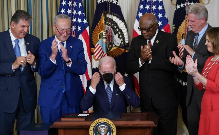 President Biden puts on his mask after signing the Inflation Reduction Act of 2022, in the State Dining Room of the White House in Washington, DC on Aug. 16, 2022. The massive law included a complicated tax credit for electric vehicles.