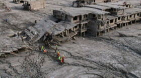 A drone view shows rescue workers inspect the area and damaged structures following recent flash flooding along the Trishuli River in the Devighat area of Nuwakot district, Nepal, Saturday, Aug. 29, 2026.