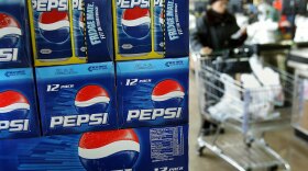 A shopper passes a display of 12-packs of Pepsi at a market in Des Plaines, Illinois.