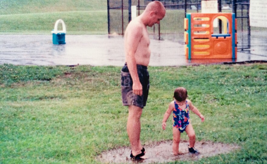 Chris and 1 1/2-year-old Kayley play in mud puddles.