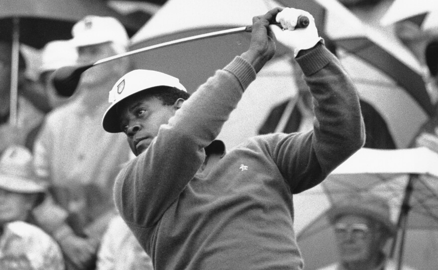 Lee Elder watches the flight of his ball as he tees off in the first round of play at the Masters in Augusta, Ga., on April 10, 1975. Elder broke racial barriers as the first Black golfer to play in the Masters and paved the way for Tiger Woods and others to follow.