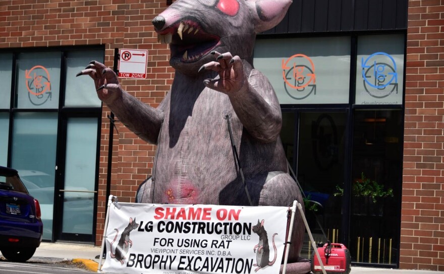 An inflatable Scabby the Rat outside of LG Construction in Chicago. The banner in front of the rat shows the union is shaming the construction company for doing business with Brophy Excavation.