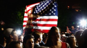 Students gather at the fence on the north side of the White House, pose for photographs, chant 'U.S.A.! U.S.A.!' and sing the Star Spangled Banner while U.S. President Barack Obama announces the death of Osama Bin Laden during a late evening statement to the press in the East Room of the White House May 1, 2011 in Washington, DC. 