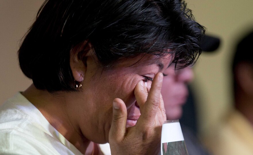 A relative holding a picture of one of the missing students, wipes a tear from her face during a press conference in Mexico, City.