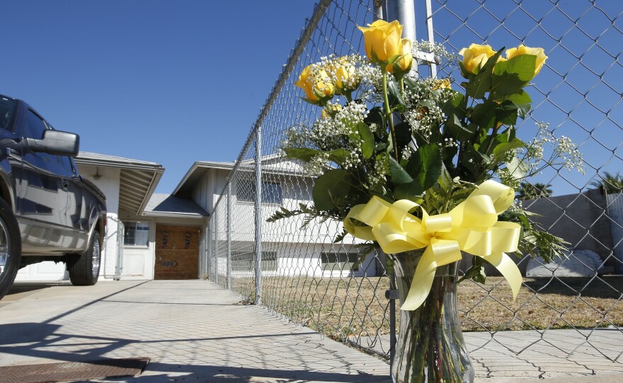 A lone bouquet of flowers stands in front of a home in Phoenix in 2013, after police said a man killed his wife, daughter and brother-in-law before killing himself. A new CDC report sheds light on patterns in homicides of women.