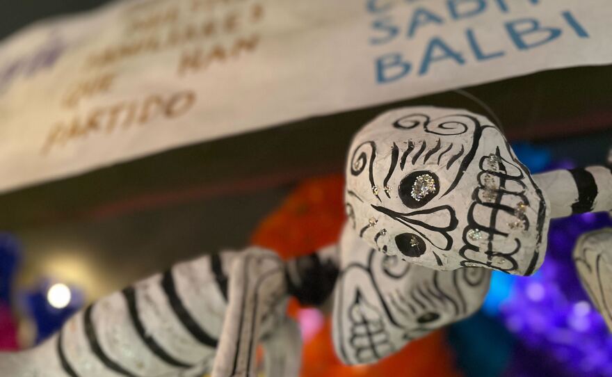 Papier-mâché skeletons hang above an altar at the Sherman Heights Community Center on Oct. 9, 2025.