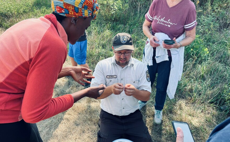 Park Ranger Peter Rae shows volunteers the proper way to apply a tracking label to a Monarch butterfly at the DeSoto National Wildlife Refuge.