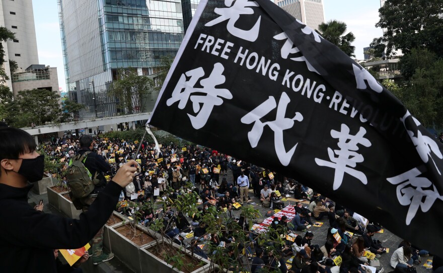 "China urges the U.S. to correct its mistake and stop meddling in Hong Kong affairs," a government spokesperson says, as China retaliates for U.S. support of pro-democracy demonstrators. Here, an activist holds a flag at a lunchtime protest Monday at Chater Garden in Hong Kong.