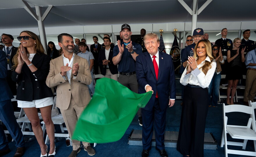 President  Trump waves the green flag to start the race alongside first lady Melania Trump, right, and from left, Bettina Trump and Donald Trump Jr. during the IndyCar Freedom 250 Grand Prix race.