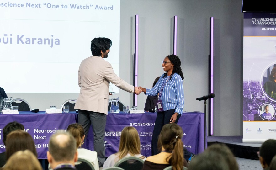 Wambūi Karanja of Kenya accepts the "One to Watch" award from the Alzheimer's Association for the guide she's developed to help family caregivers.