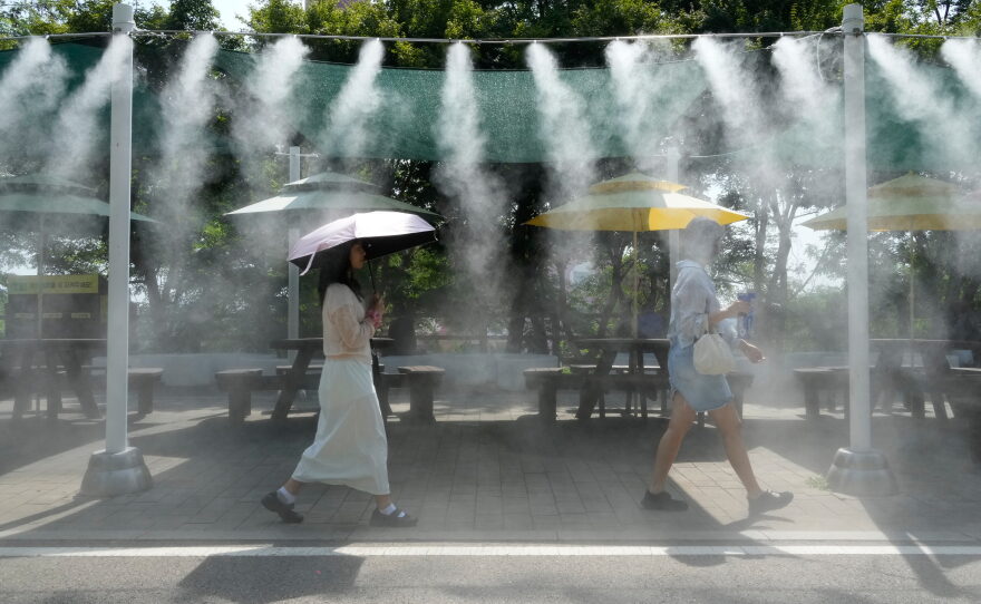 Visitors pass by the cooling fog device at Gwangmyeong Cave tourist site in Gwangmyeong, South Korea, Aug. 6, 2026.
