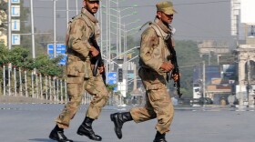 Pakistani troops take up positions at army headquarters during an encounter with militants Sunday in Rawalpindi. Pakistani troops stormed army headquarters to end a day-long hostage drama, freeing 39 people held by militants who brazenly struck at the heart of the country's military establishment.