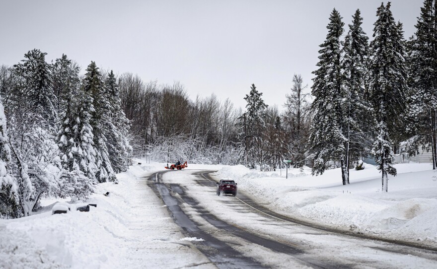 A car slowly travels down a road after a second round of snow passed through northern Minnesota Thursday, Dec. 15, 2022, in Duluth, Minn.