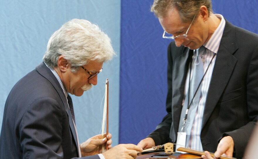 Appraisers Fred Oster (left) and David Bonsey, review a 1920 French violin at an Antiques Roadshow event in Los Angeles in 2005. Many stringed instruments throughout history have been made using small amounts of ivory.