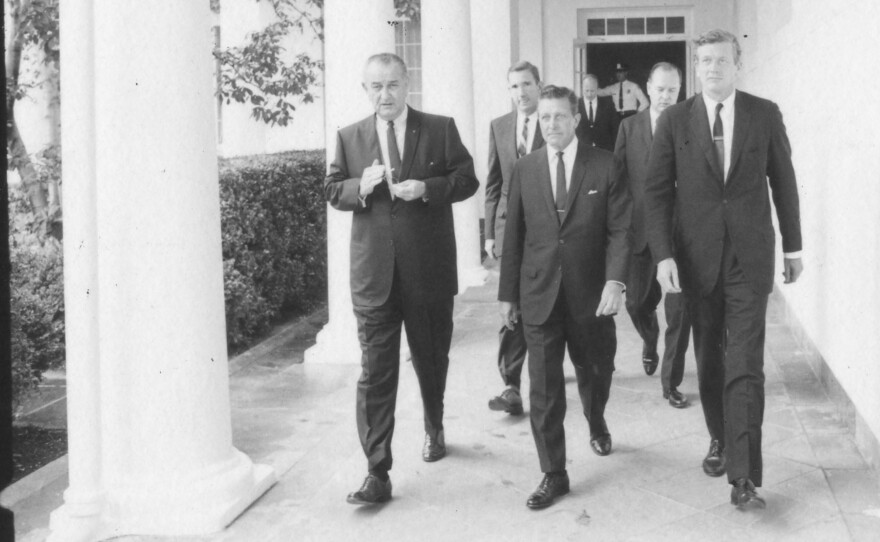 Left to right, front row: President Lyndon Johnson; Governor Otto Kerner, Jr., of Ill., chair of the Kerner Commission; and John Lindsay, Mayor of New York and vice chair of the commission, walking on an outdoor pathway to the West Wing. July 29, 1967.