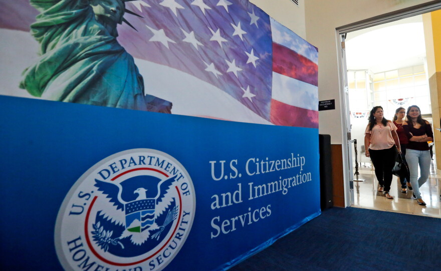 In this Aug. 17, 2018, file photo, people arrive before the start of a naturalization ceremony at the U.S. Citizenship and Immigration Services Miami Field Office in Miami.