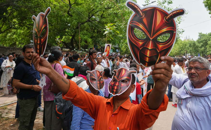 Supporters of the Cockroach Janta Party wear and display masks during a protest in New Delhi, Saturday.