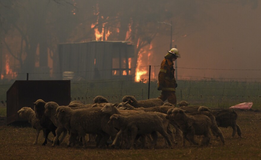 Rural Fire Service officers protect property from the Green Wattle Creek Fire along the Old Hume Highway near the town of Tahmoor in New South Wales.