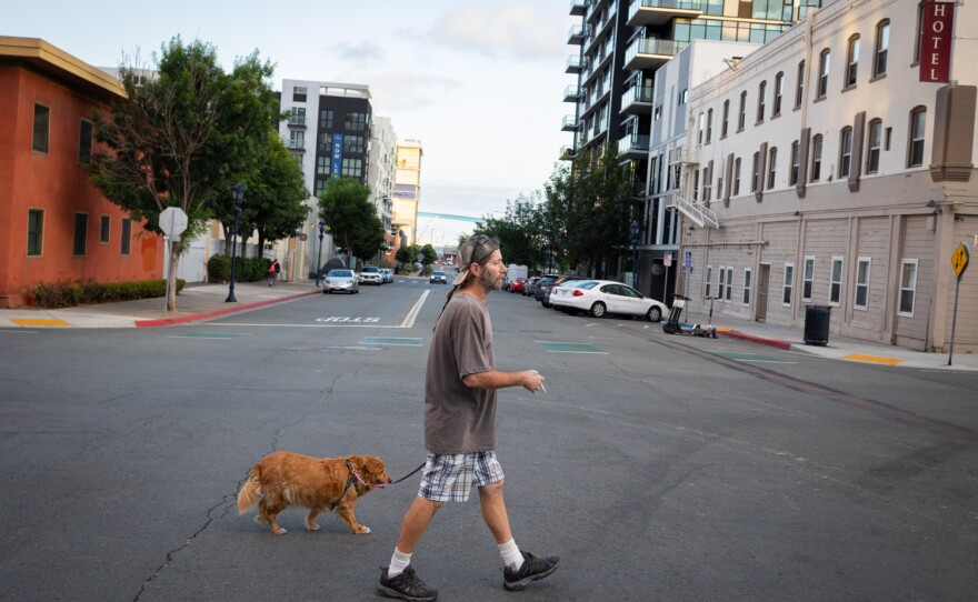Arley Adcock walks with his dog, Cheyenne, in San Diego on June 8, 2023.