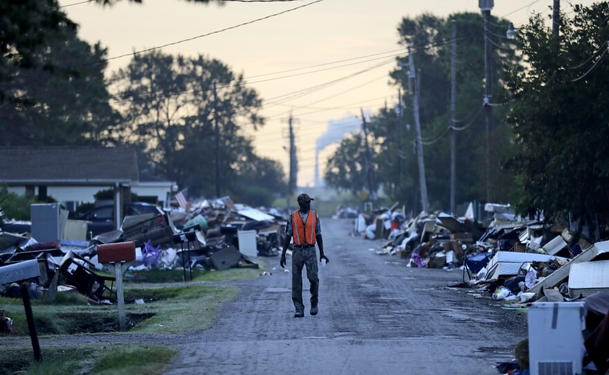 A man walks past debris from Hurricane Harvey in September in Port Arthur, Texas.