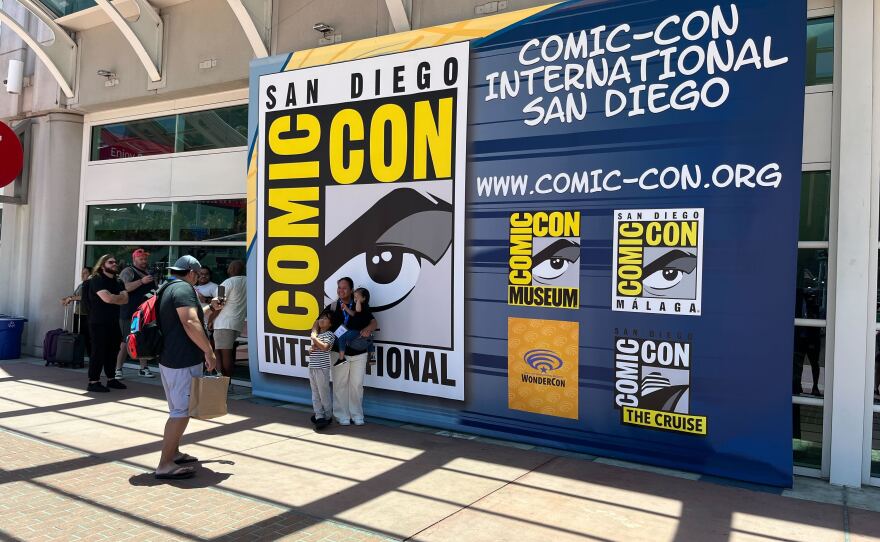 Comic-Con attendees take photos in front of a Comic-Con International sign on July, 23, 2025. 