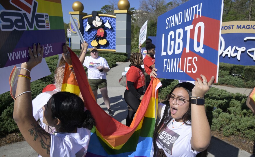 LGBTQ advocates march at a rally at Walt Disney World in Orlando, Fla., to urge the company to publicly oppose what they call the "Don't Say Gay" that aims to limit instruction of gender identity and sexual orientation in schools.