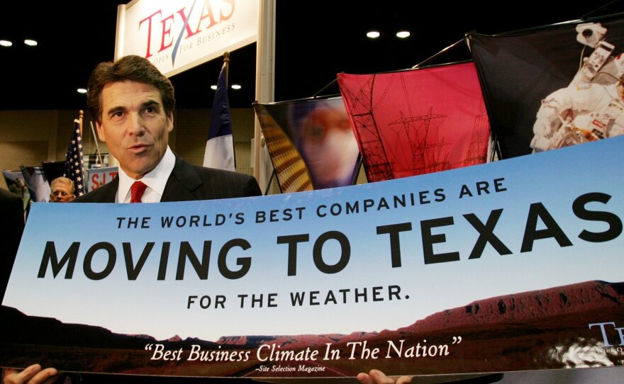 Texas Gov. Rick Perry holds a sign promoting business in Texas, in San Antonio, on Nov. 8, 2004. Nearly a decade later, Perry is still touting the state's pro-business bent, including a