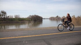 A bicyclist rides along a public levee in the Pocket neighborhood in Sacramento, Feb. 11, 2016. 