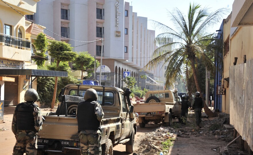 Malian troops take position outside the Radisson Blu hotel in Bamako Friday. Gunmen went on a shooting rampage at the luxury hotel in the capital of Bamako, seizing 170 guests and staff.